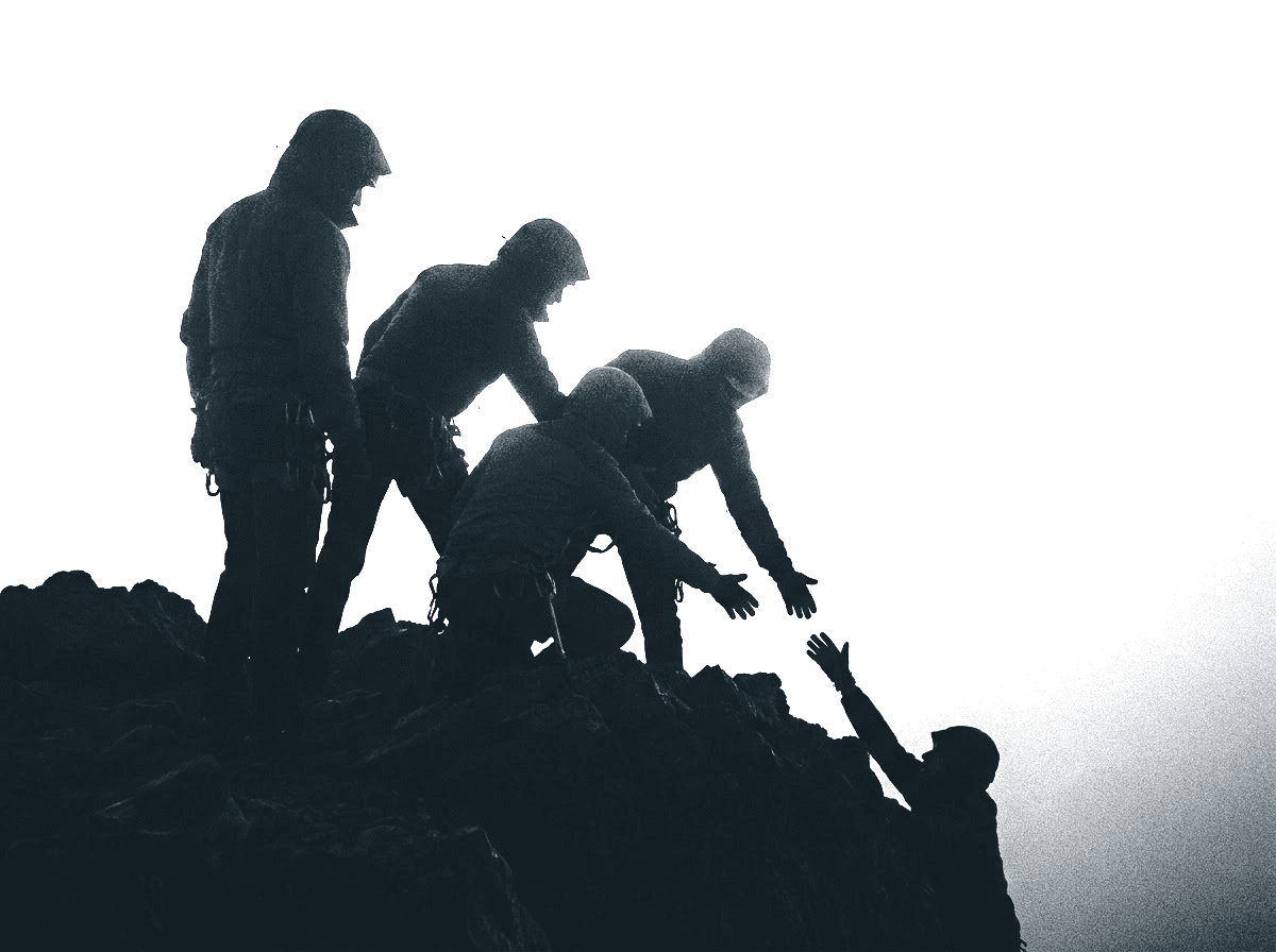 A group of climbers reaching down to help one person up over the ridge